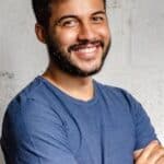 Portrait of a happy man with arms crossed, exuding confidence and friendliness.